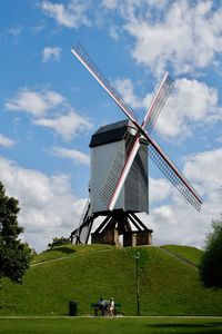 Traditional windmill on field against sky