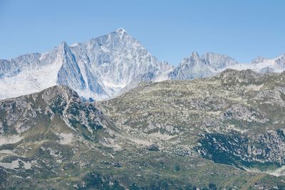 Scenic view of snowcapped mountains against clear blue sky