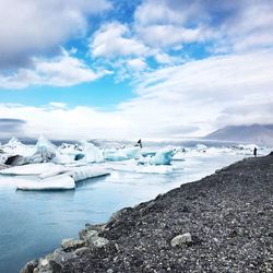 Scenic view of glacier lagoon against cloudy sky