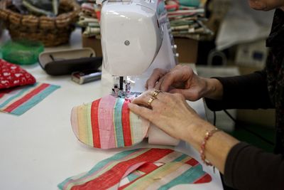 Midsection of woman working on sewing machine