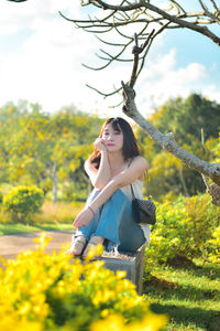 Portrait of smiling young woman standing on field