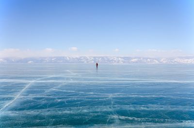 Person on sea against blue sky