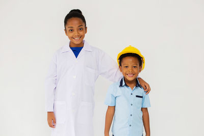 Portrait of smiling boy standing against white background