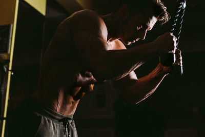 Shirtless man exercising in gym