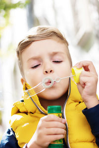 Portrait of cute boy holding yellow outdoors