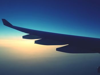 Cropped image of airplane flying over clouds