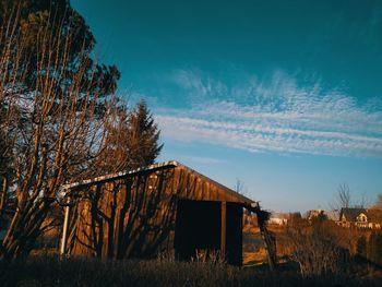 Abandoned house on field against sky at sunset