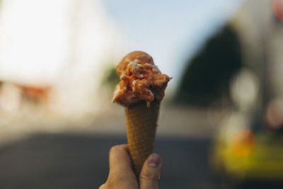 Close-up of hand holding ice cream on street