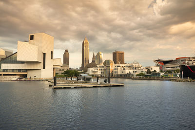 Buildings in city against cloudy sky