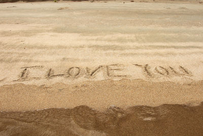 High angle view of text on sand at beach