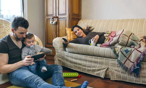 Siblings playing on sofa at home