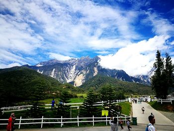 People on mountain against blue sky