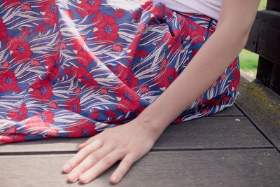 Low section of woman sitting on sidewalk