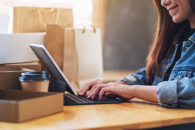 Midsection of woman using laptop on table