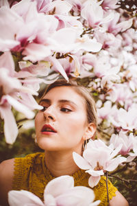 Young woman amidst pink flowers