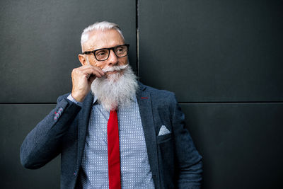 Businessman standing against black wall