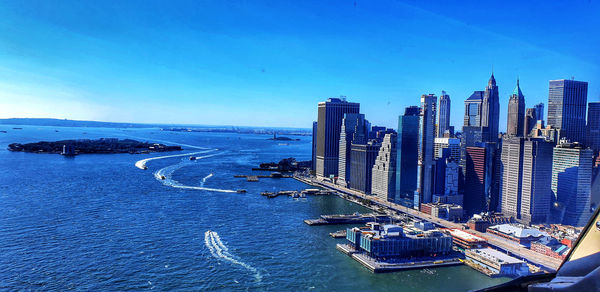 Panoramic view of sea and buildings against clear blue sky