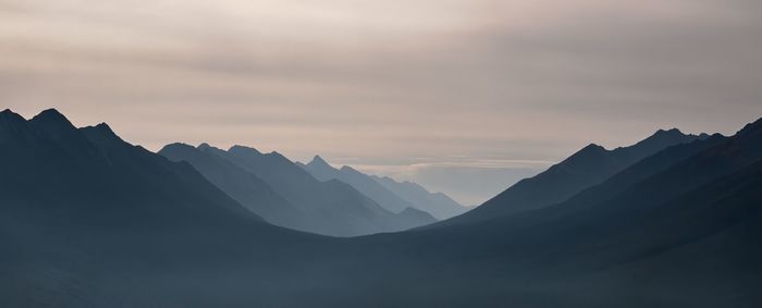 Scenic view of silhouette mountains against sky during sunset