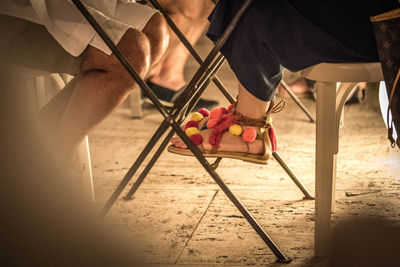 Low section of woman sitting on chair at outdoor cafe