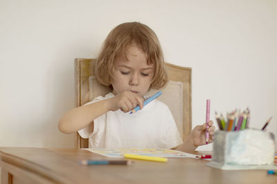 Full length of boy sitting on table