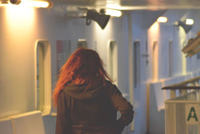 Rear view of woman standing in boat