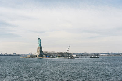 Statue of liberty and upper bay against cloudy sky
