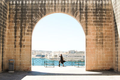 Man walking on archway of building