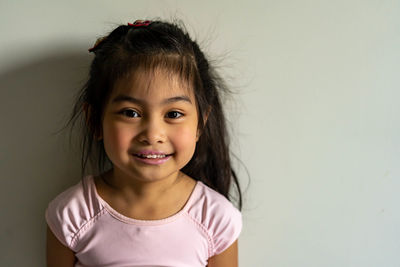 Portrait of smiling girl against white background