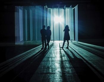 People in illuminated corridor