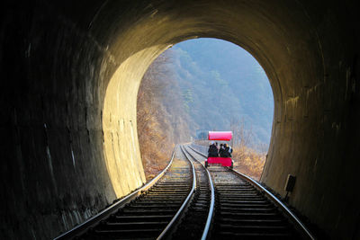 Rear view of man on railroad tracks in tunnel