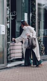 Full length of woman standing on footpath