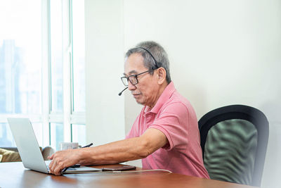 Man using mobile phone while sitting on table