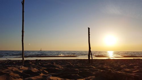 Scenic view of beach against clear sky during sunset