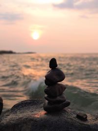 Stack of stones on beach during sunset