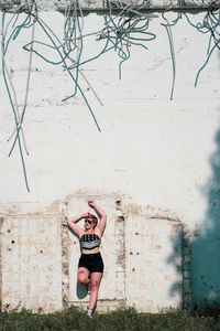 Portrait of woman standing against wall