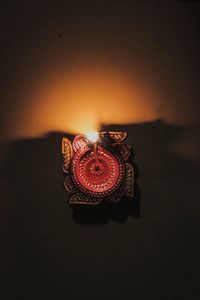 Close-up of illuminated electric lamp against wall at home