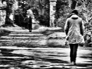 Rear view of woman walking on road