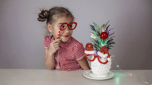 Portrait of young woman sitting on table at home