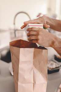 Close-up of hand holding ice cream on table