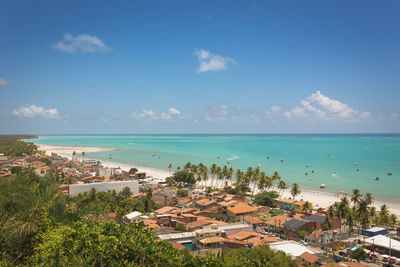 High angle view of buildings by sea against sky