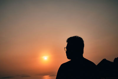 Silhouette man standing against sky during sunset