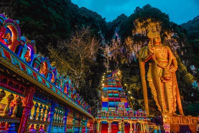 Low angle view of illuminated temple against building