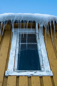 Low angle view of icicles on window