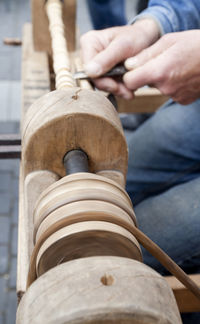 Midsection of carpenter carving wood at workshop