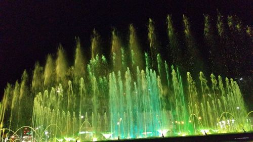 Low angle view of illuminated water against sky at night
