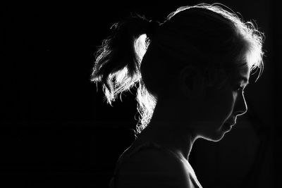 Close-up portrait of a woman against black background