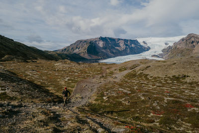 Man running next to the svinafellsjokull glacier in iceland