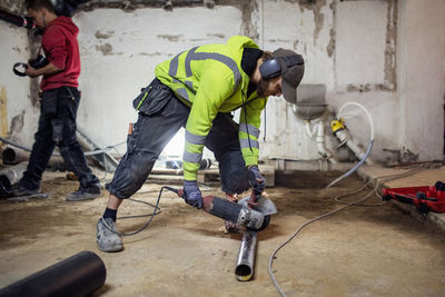 Plumbers working on pipes in abandoned basement