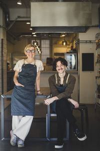 Female owner standing by male employee in store