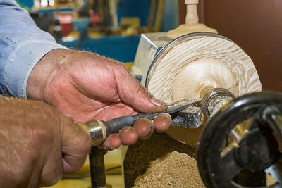 Cropped hands of carpenter holding work tool